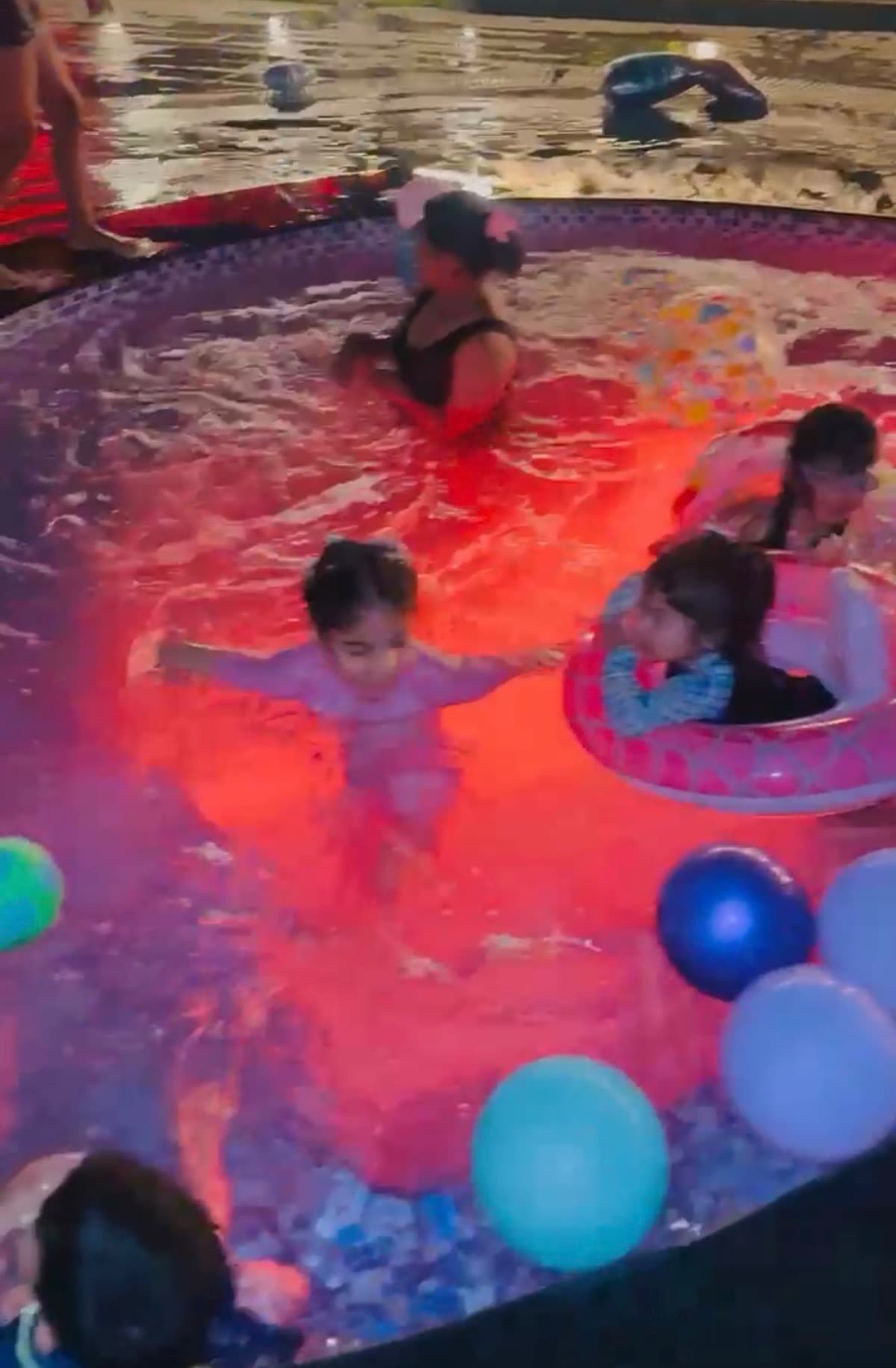 Kids enjoying the illuminated pool at night at Sidneyland Hill Retreat